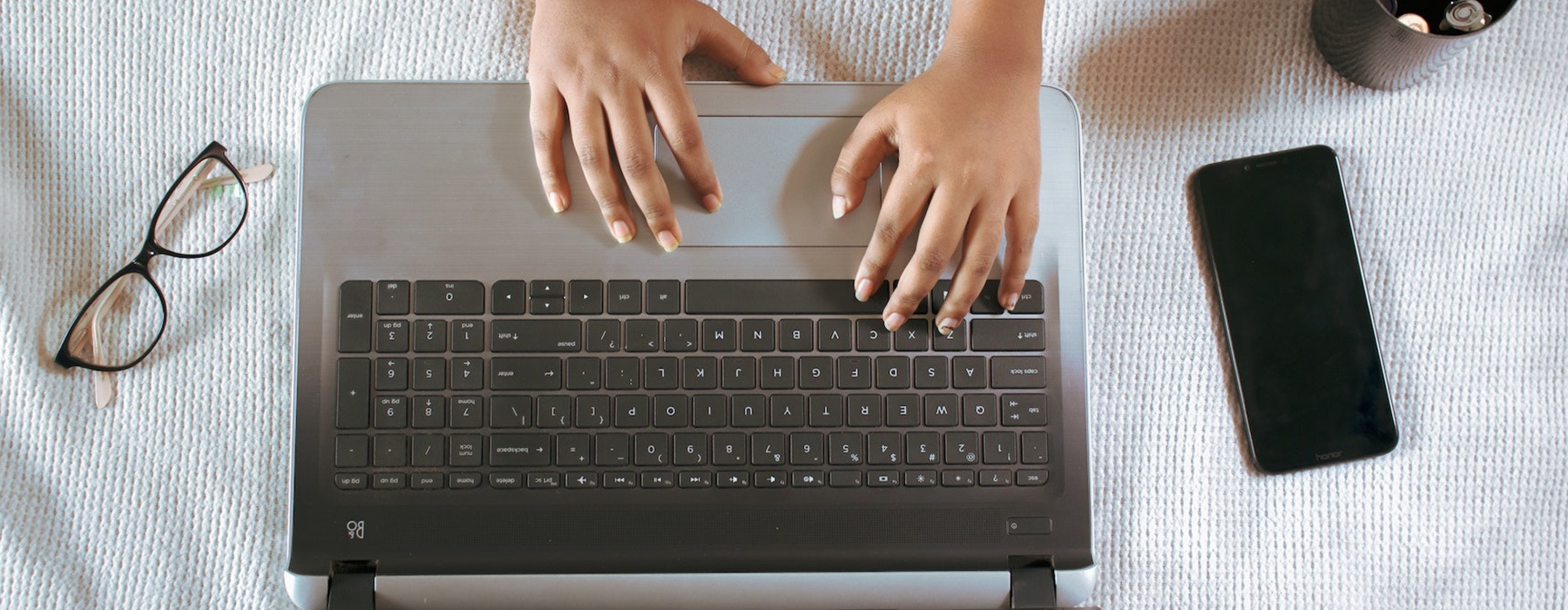 overhead view of a person typing on a laptop